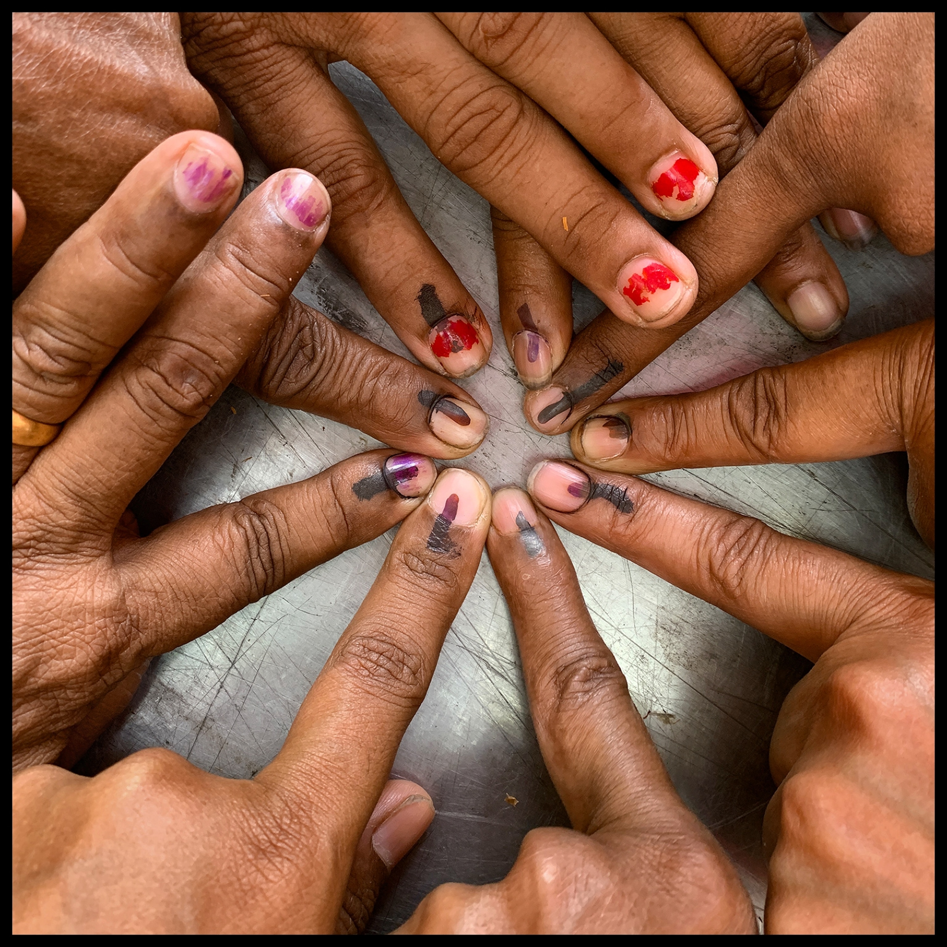 many women's fingers with ink on their fingertip