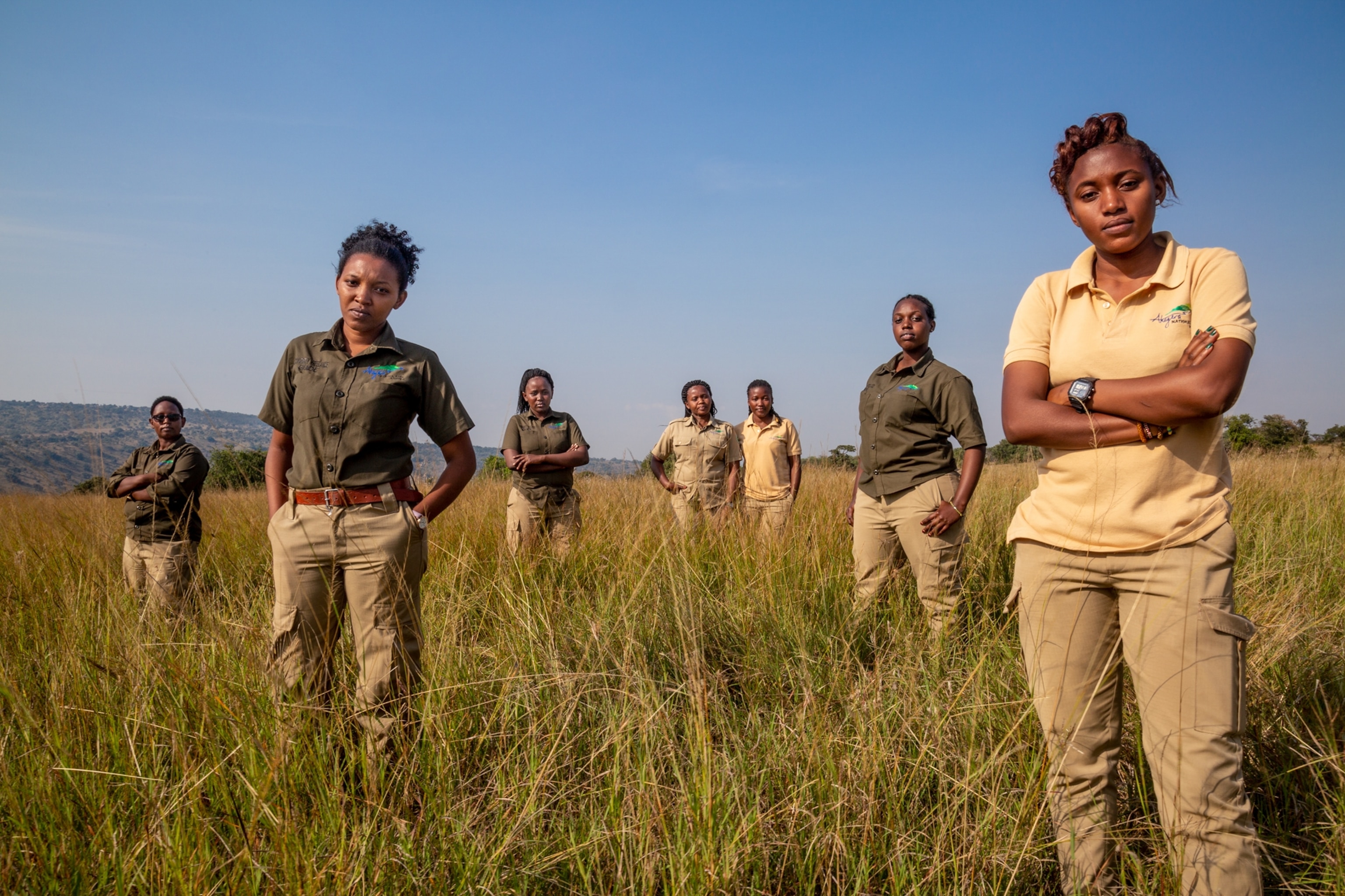 seven park guides standing in tall grass