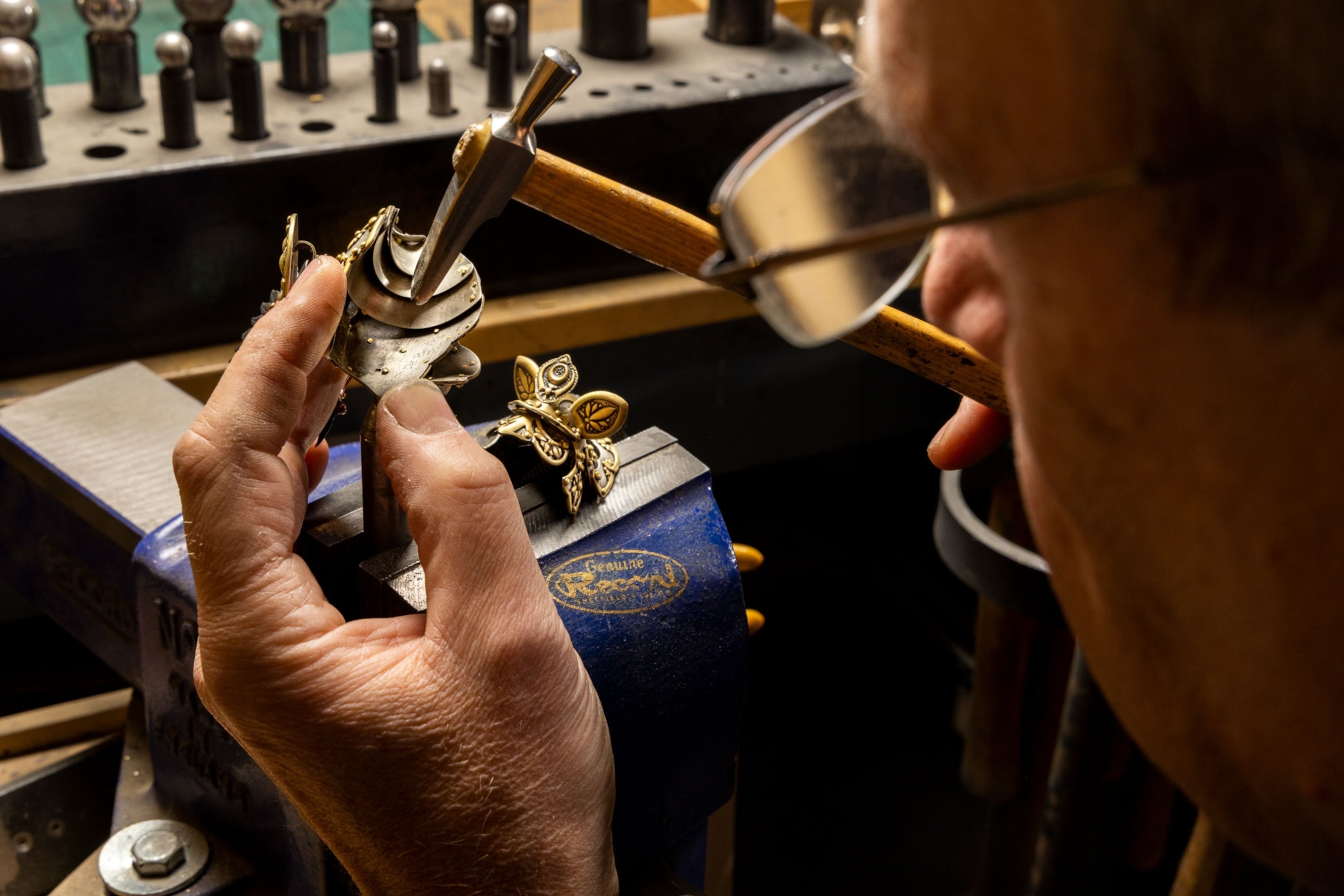 a metal artist works with gold plate in his studio