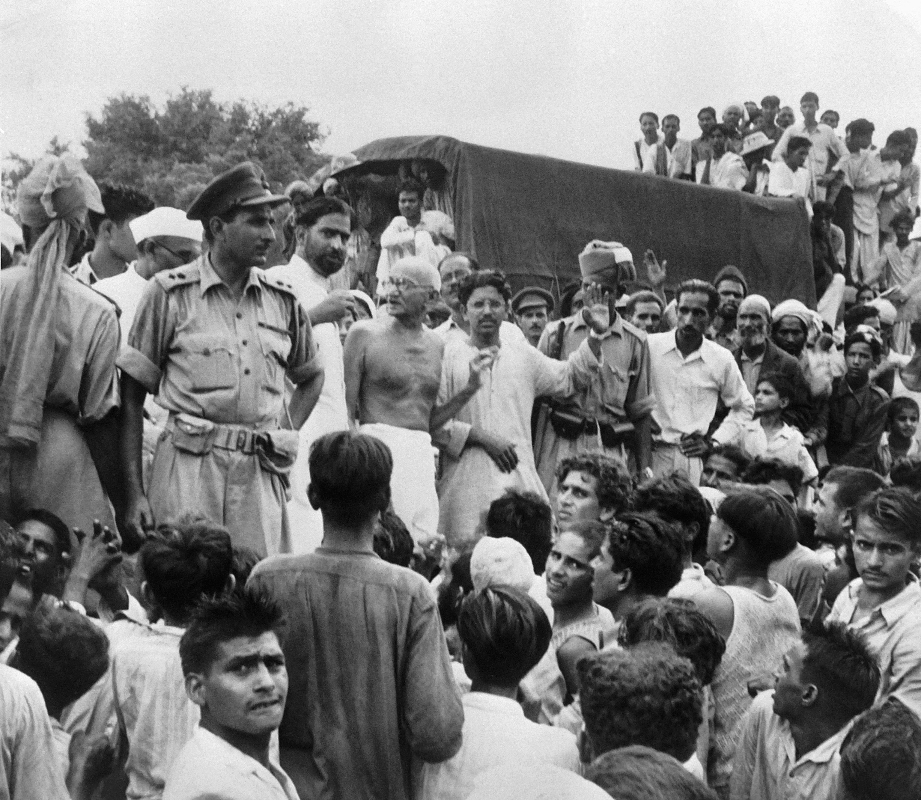 black and white photo of Mahatma Gandhi surrounded by people