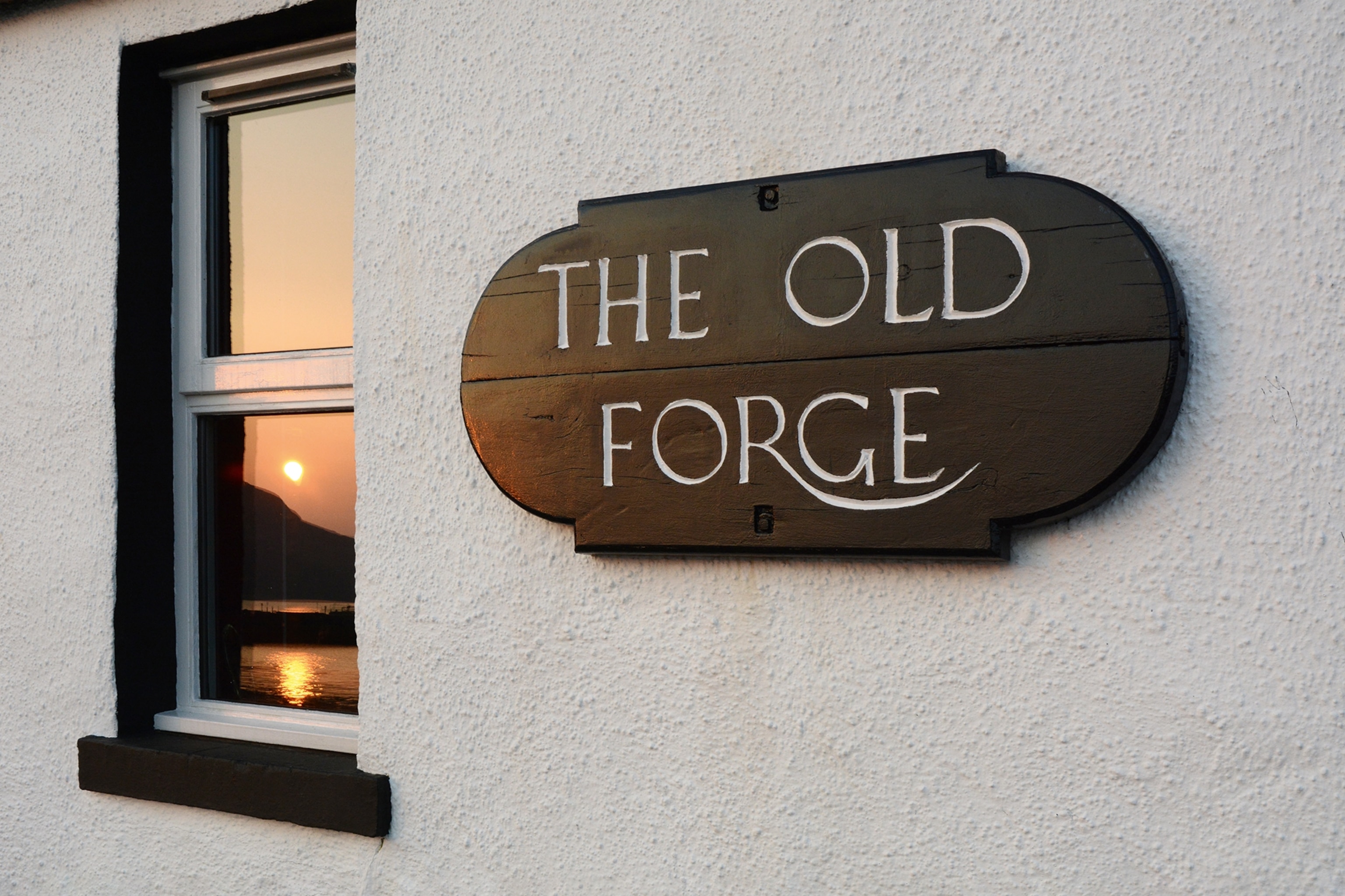 A wooden sign for the Old Forge pub