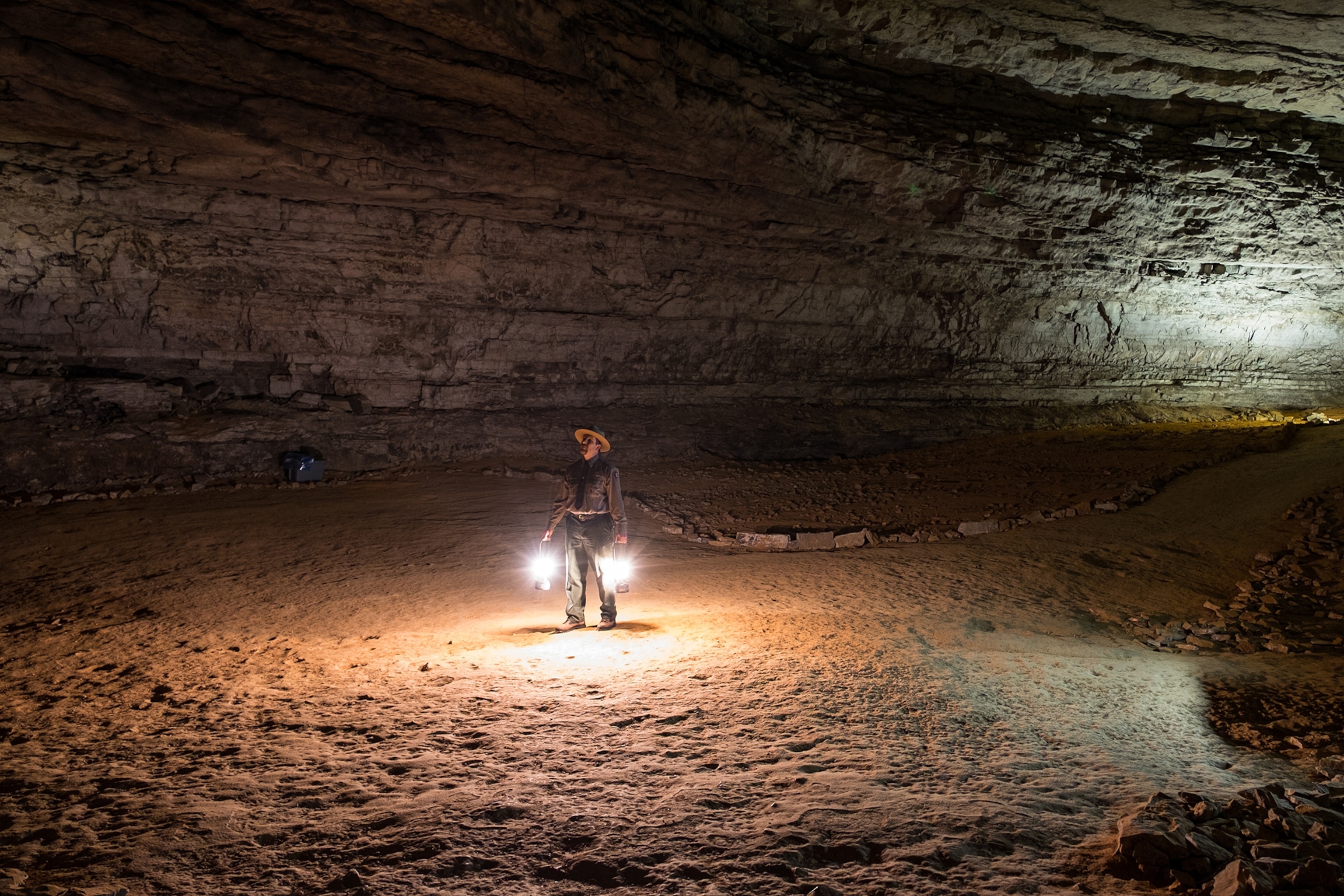 a ranger holding lanterns in a cave in Mammoth Cave National Park, Kentucky