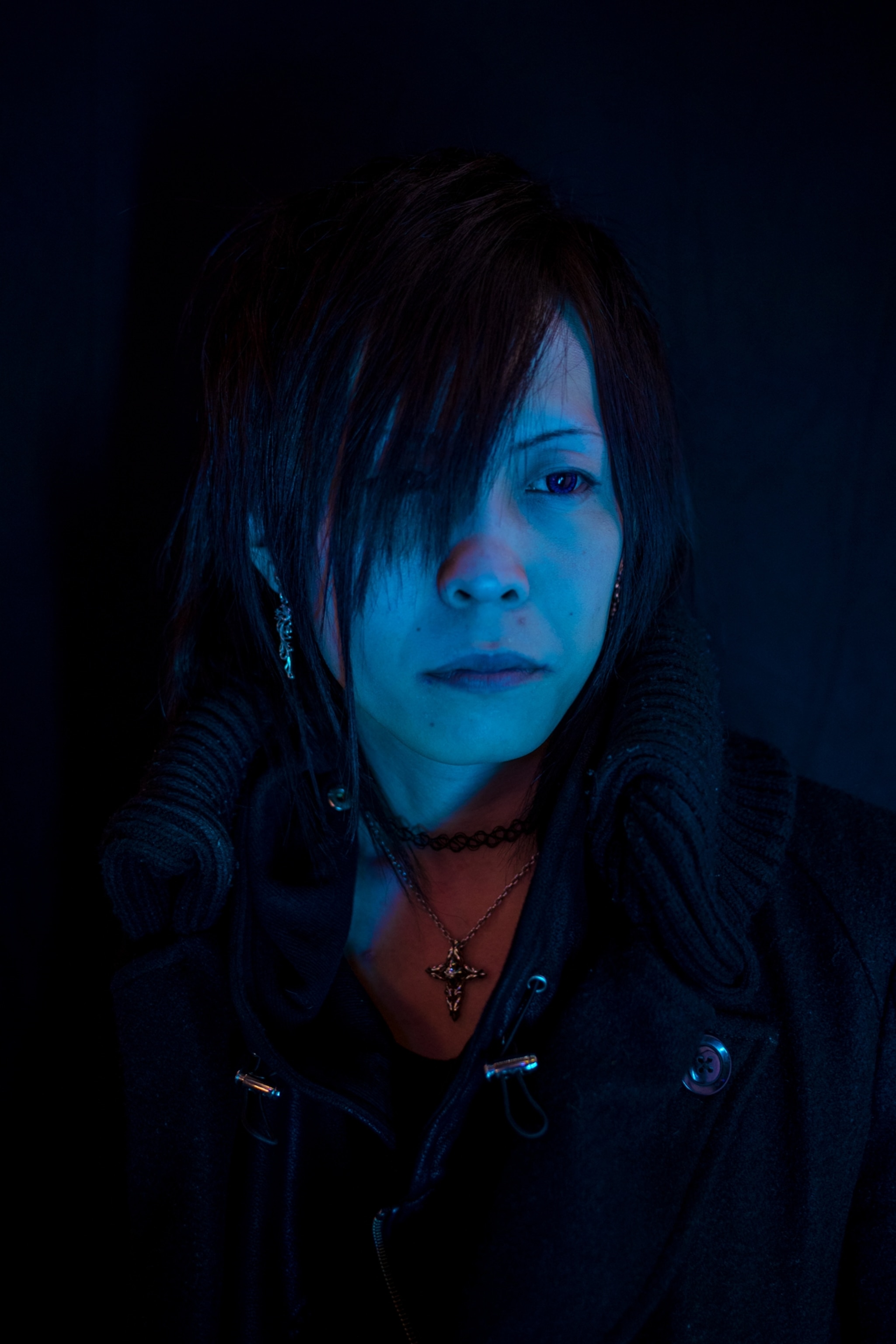 a person against a black background cast in neon blue light