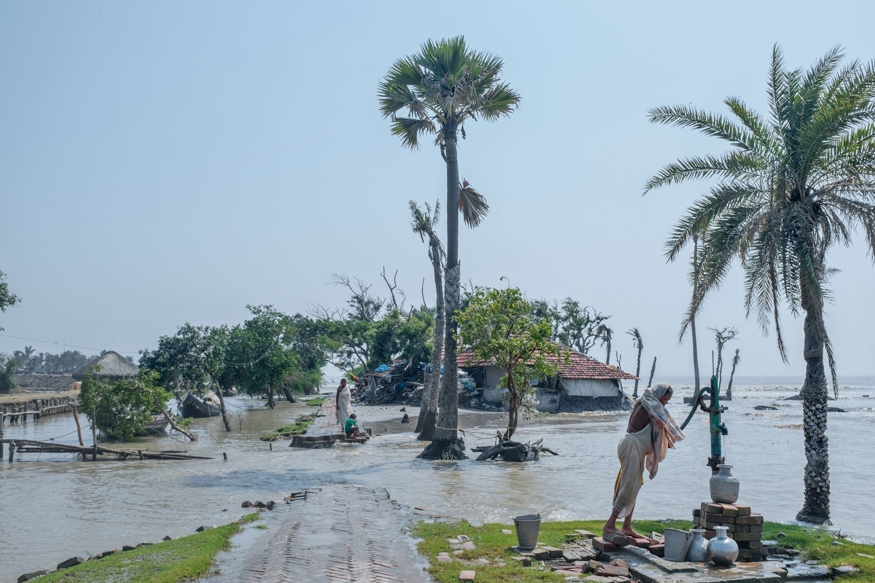 a man collecting water in a flooded area