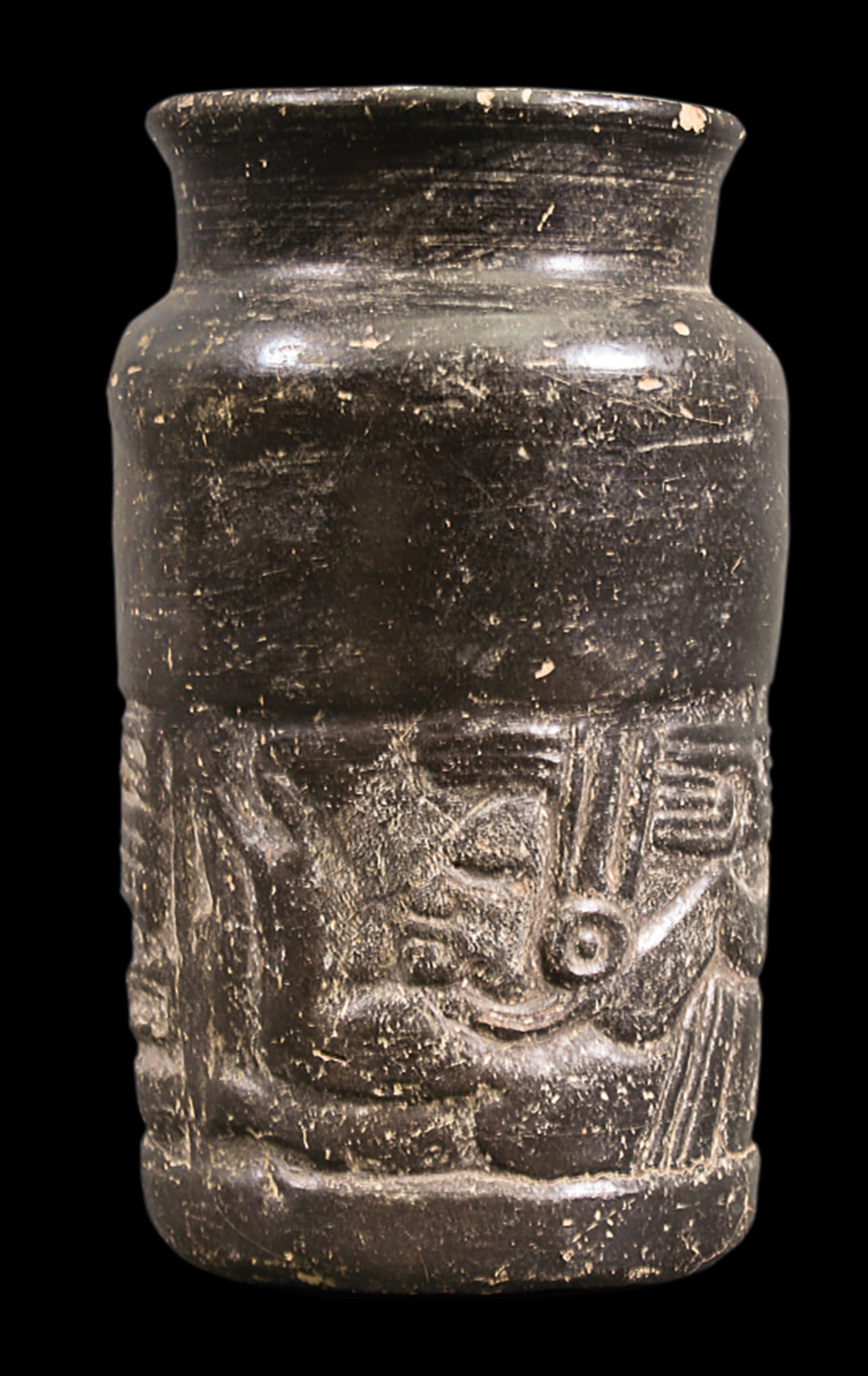 A short black vase with a scene engraved in a band on the bottom