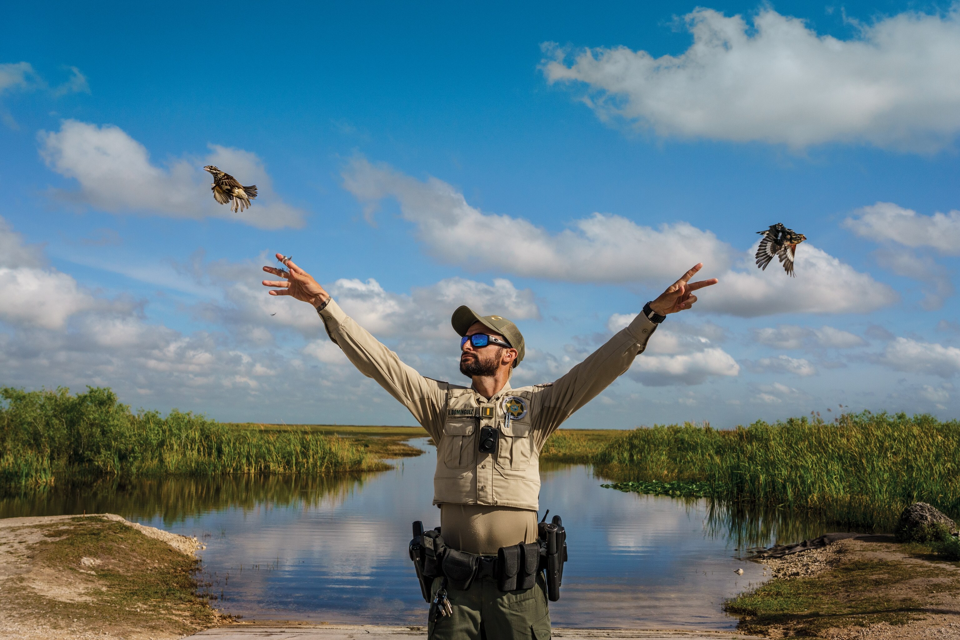 Picture of Lieutenant Antonio Dominguez with his arms outstretched as he releases a bird from each hand.