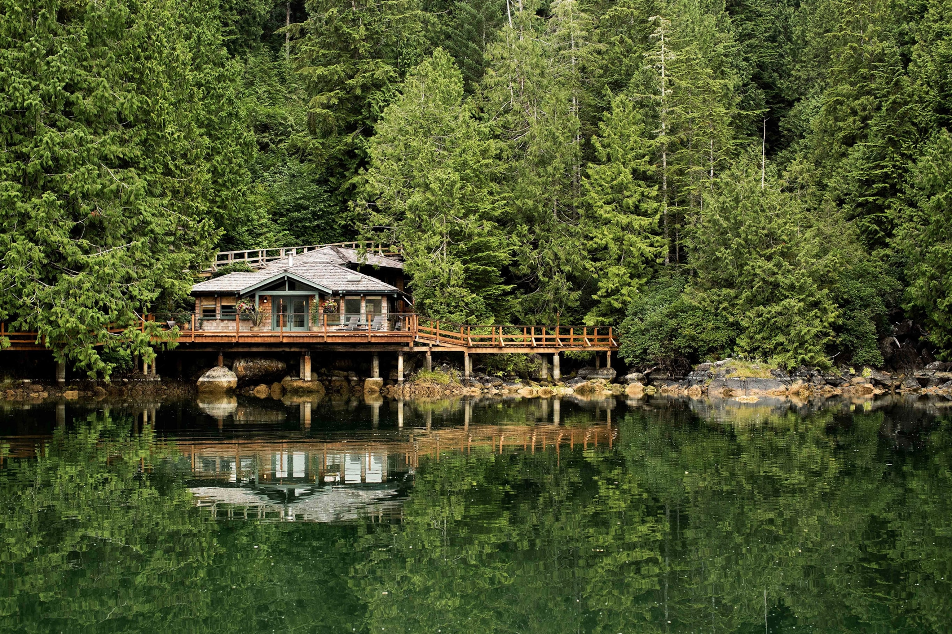The exterior of the Tofino Wilderness Resort reflected in the lake