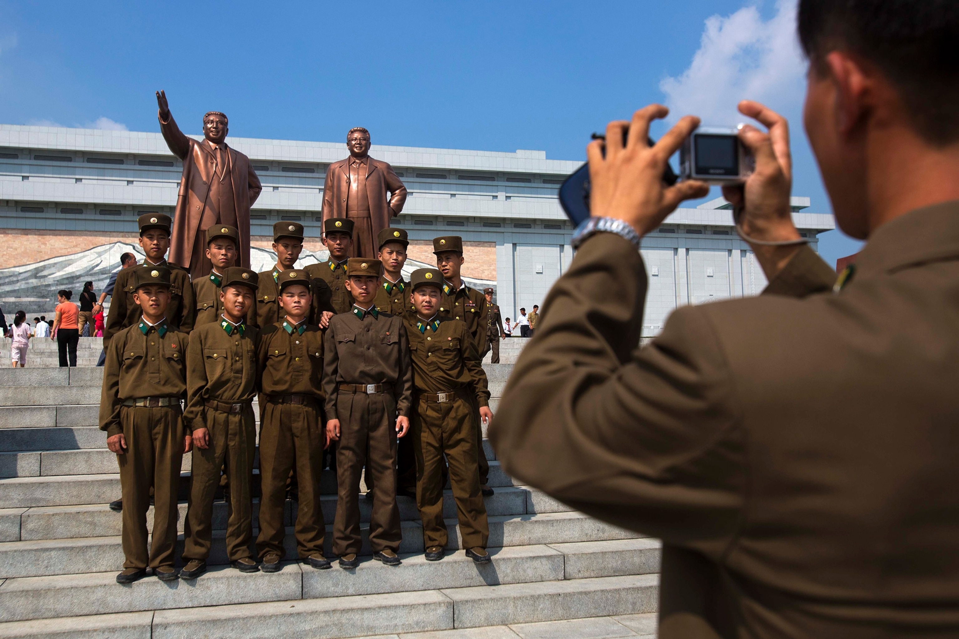 North Korean soldiers in front of a bronze statue