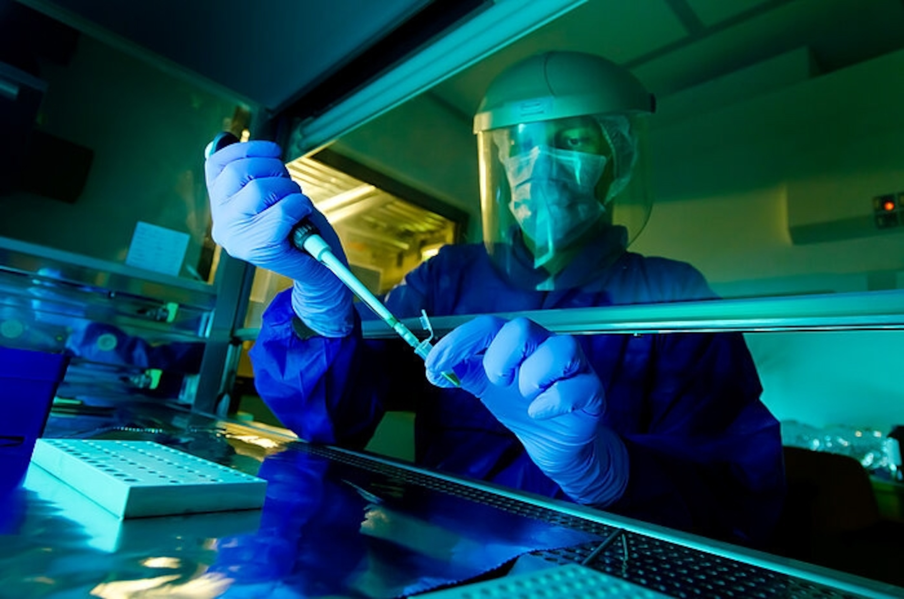 Matthias is seen wearing PPE to protect his face as he works under a lab hood to pipette a DNA sample.