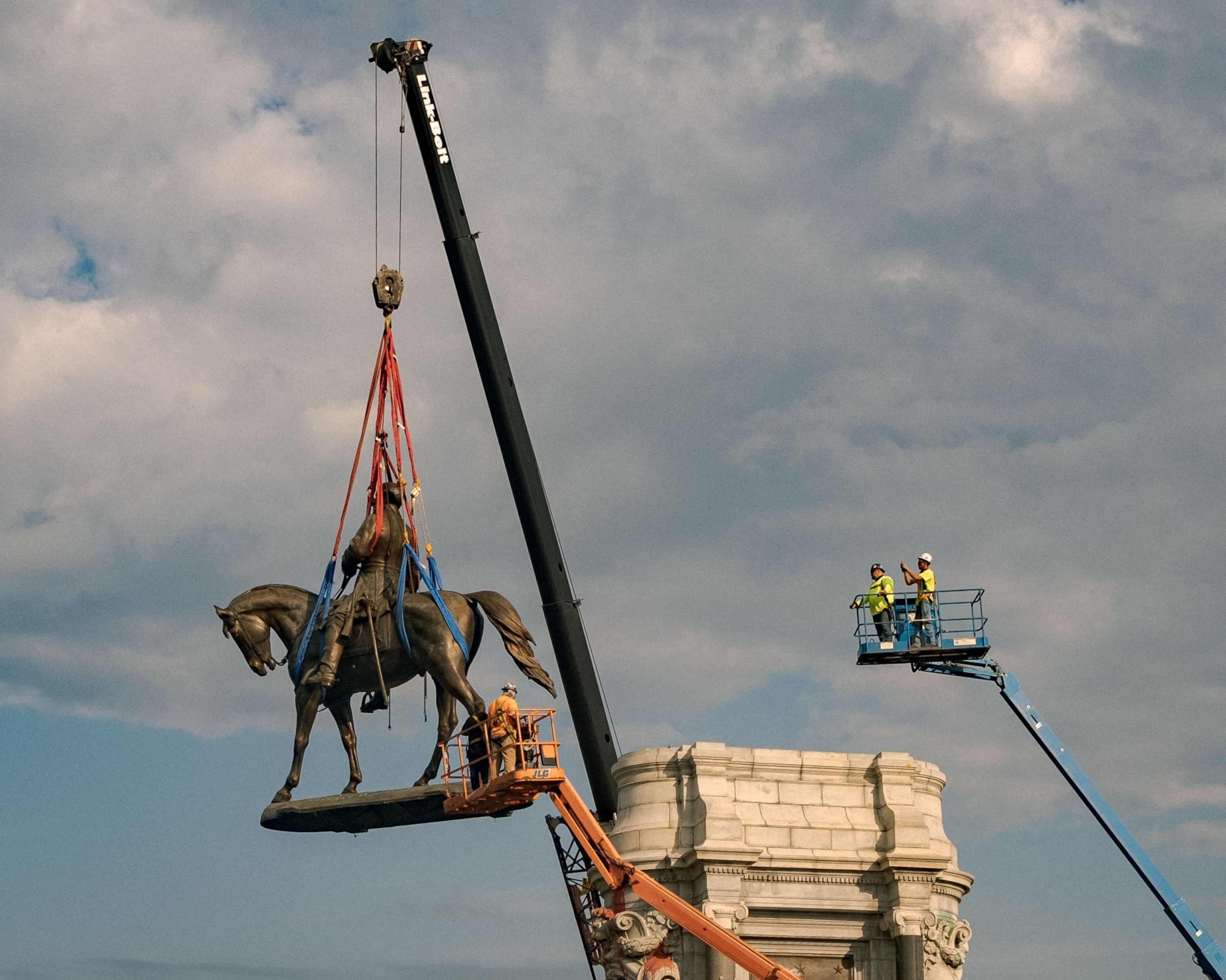 people watch as the statue of Confederate general Robert E. Lee is removed in Richmond, Virginia
