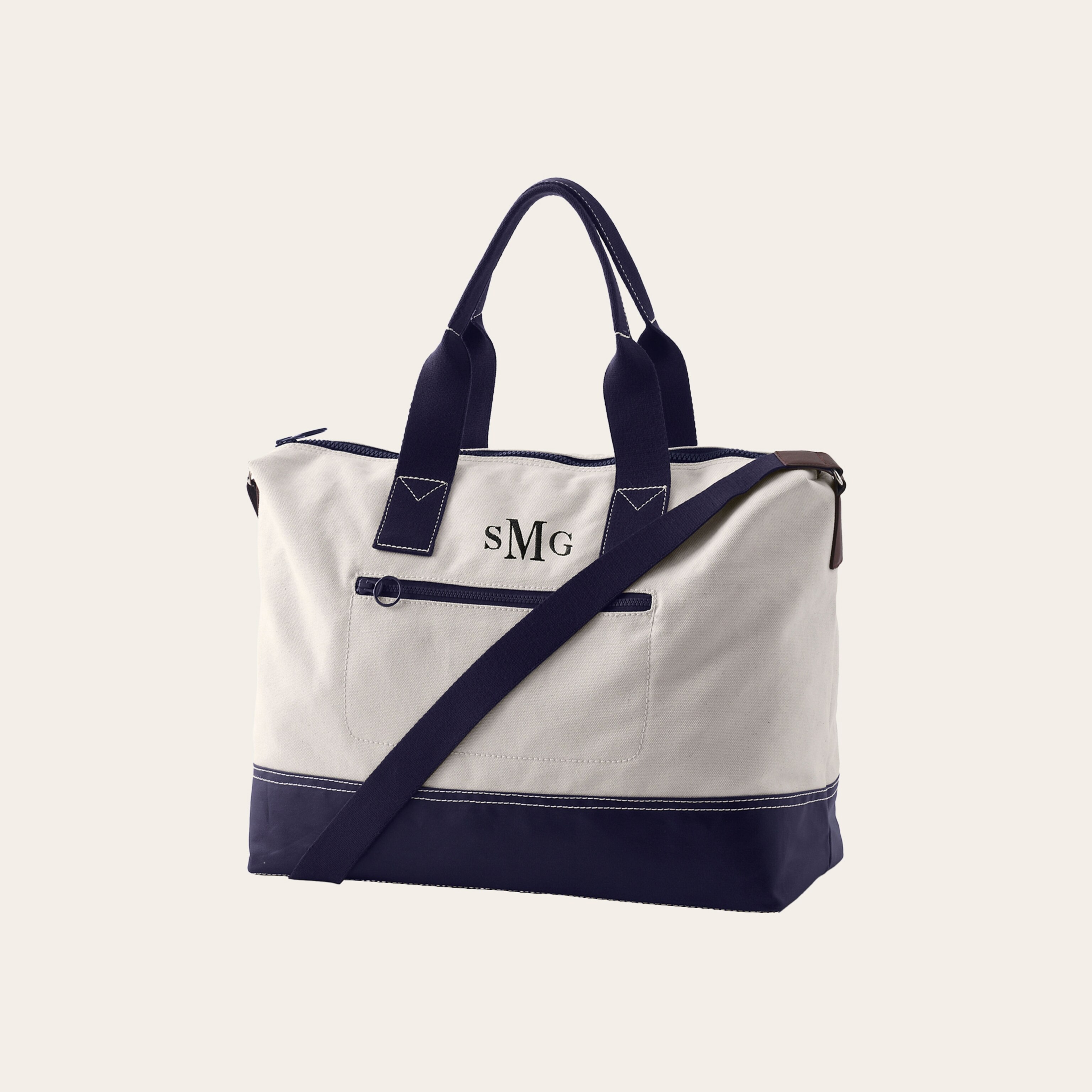 A white canvas bag with navy blue trim against a tan background.