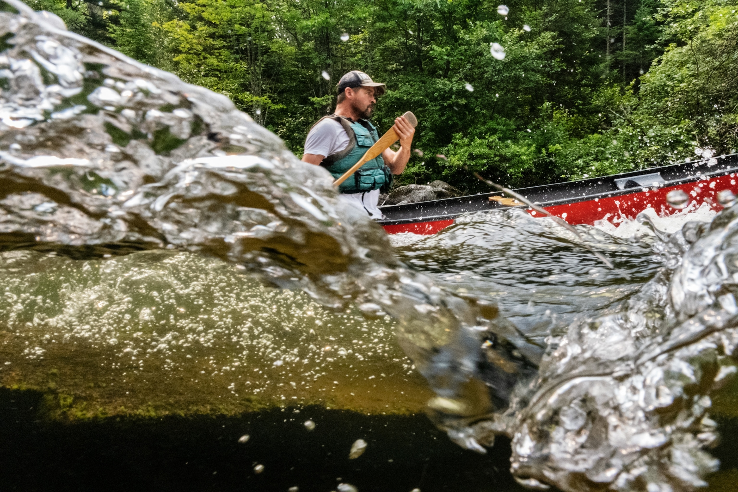 A partially underwater photograph of a canoer paddling.
