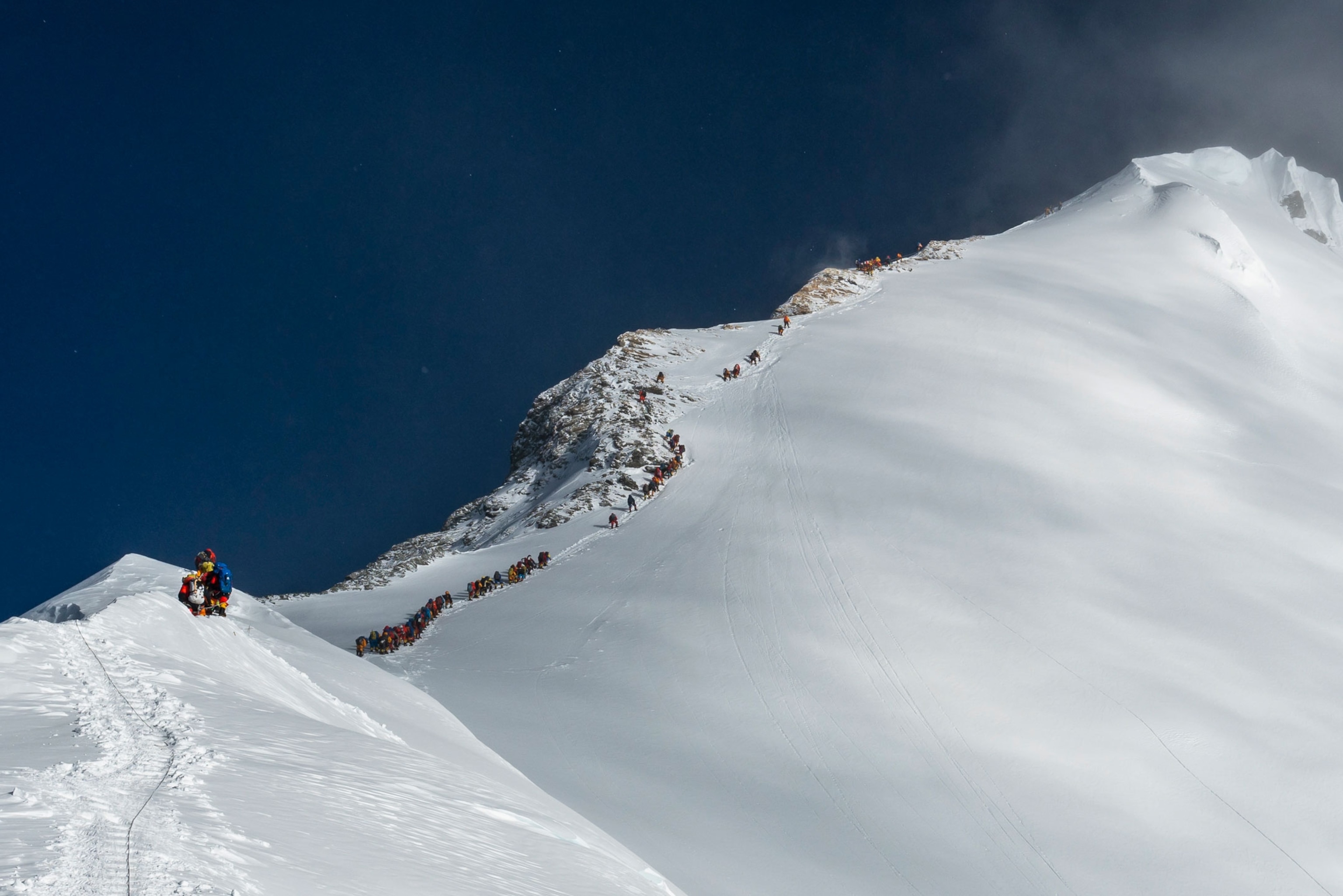 a line of climbers leading up to the summit of Mount Everest