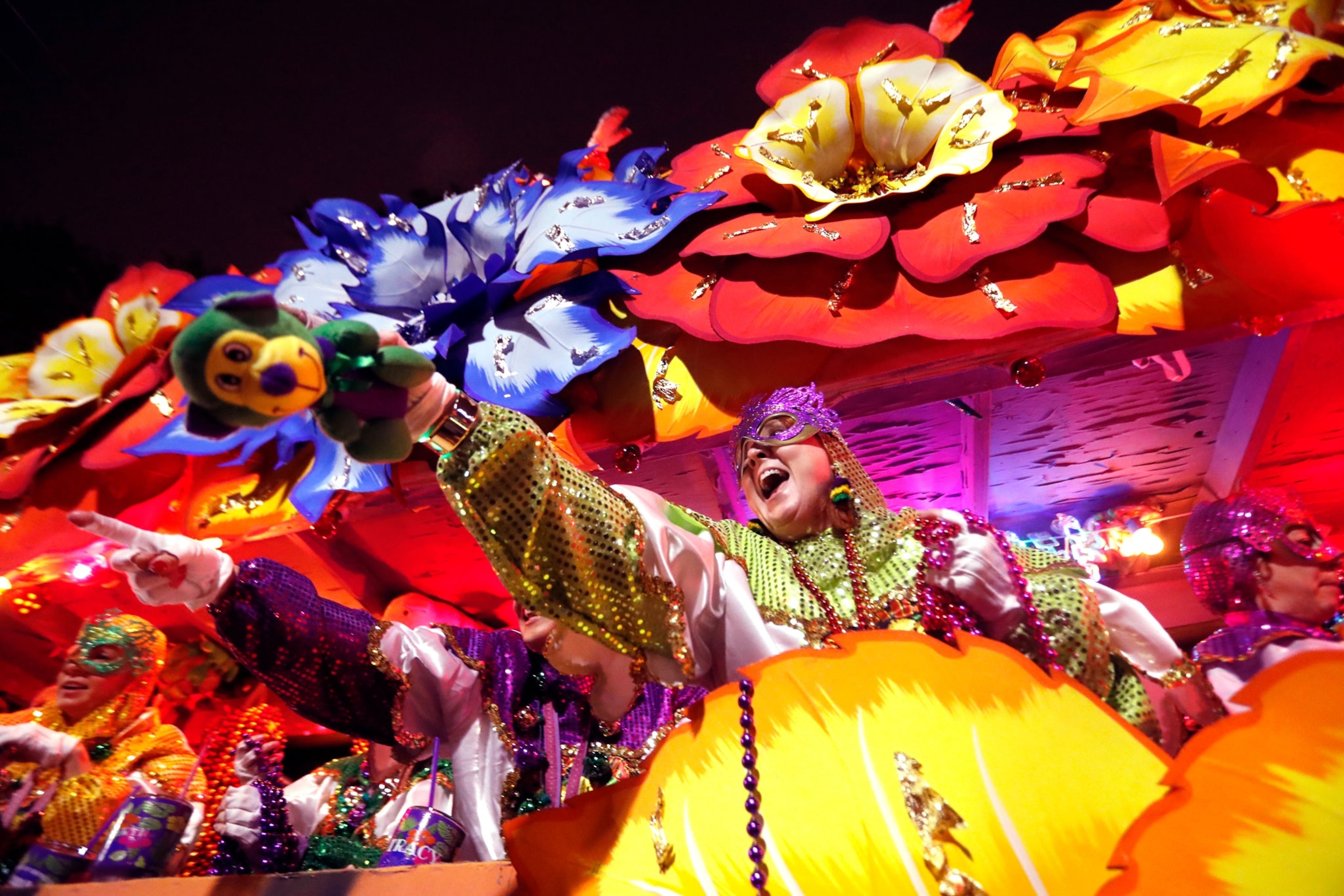 Float riders toss trinkets as the Krewe of Orpheus rolls in New Orleans