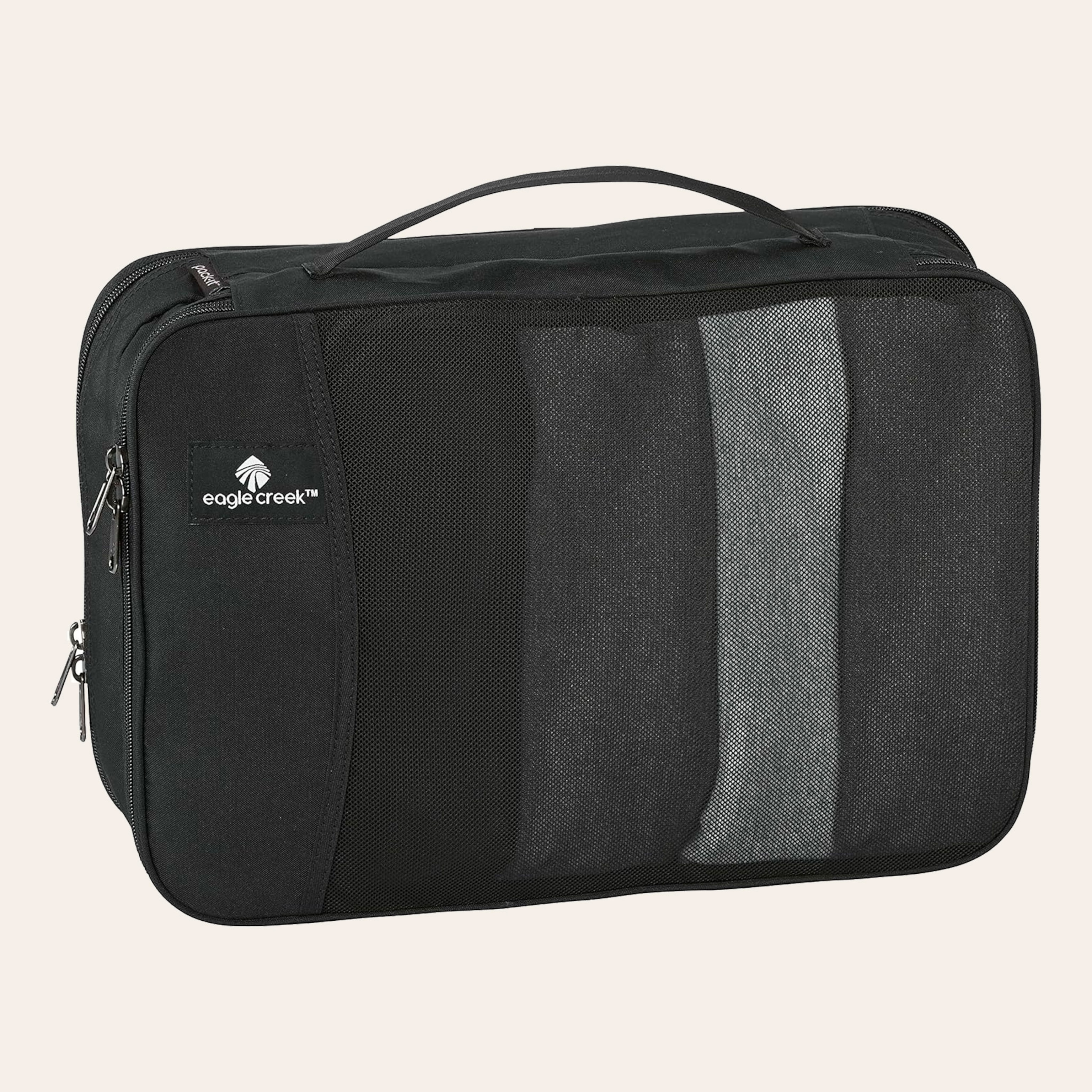 A black, rectangular, cloth case, with a handle, zippers and a black mesh pouch in the front.